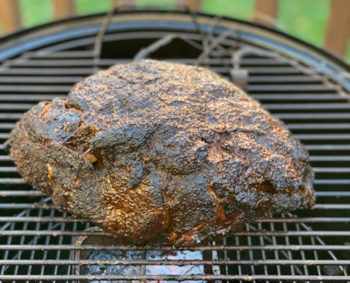 Basting the pork butt with sauce