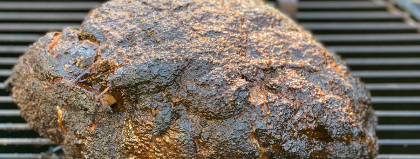 Basting the pork butt with sauce